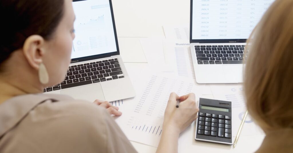 Two people analyzing business data on laptops with charts and graphs.
